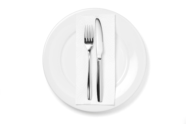 Assiette vide avec couteau et fourchette isolé sur fond blanc