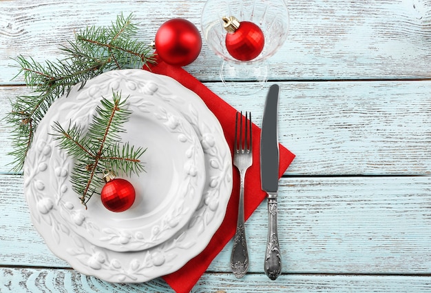 Assiette vide, couverts, serviette et verre sur fond de bois rustique. Concept de réglage de table de Noël