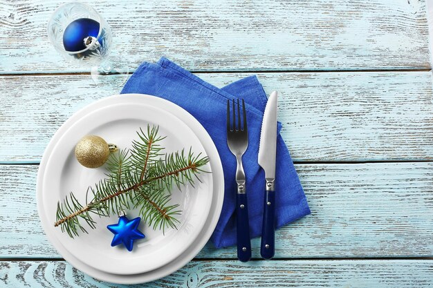 Assiette vide, couverts, serviette et verre sur fond de bois rustique. Concept de réglage de table de Noël