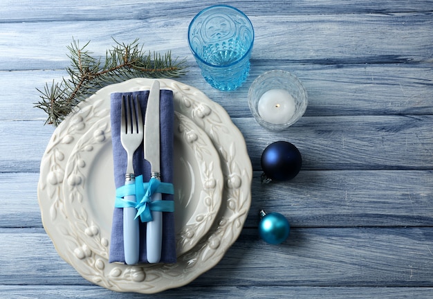 Photo assiette vide, couverts, serviette et verre sur une surface en bois rustique. concept de réglage de table de noël