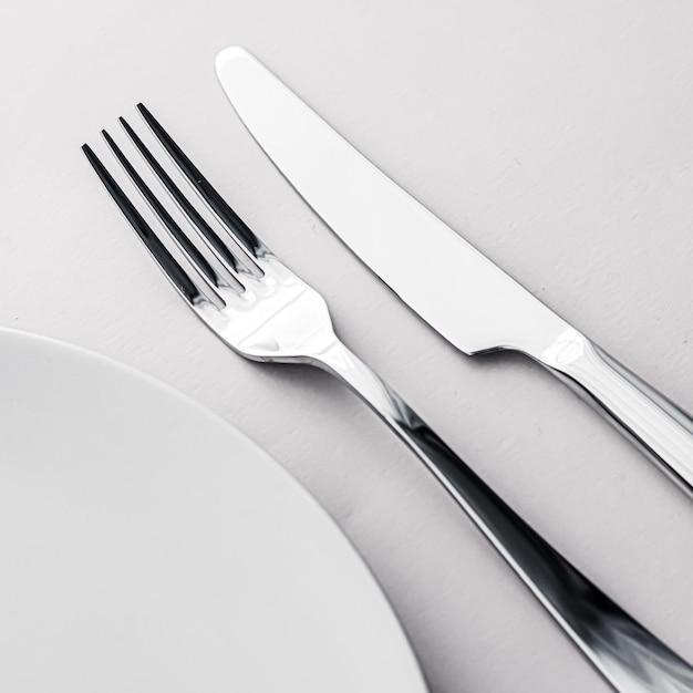Photo assiette vide et couverts en tant que maquette sur fond blanc vaisselle supérieure pour la décoration de la table du chef et la marque du menu