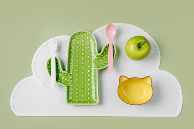 Assiette vide en forme de cactus et chat sur la table. De jolies assiettes pour enfants