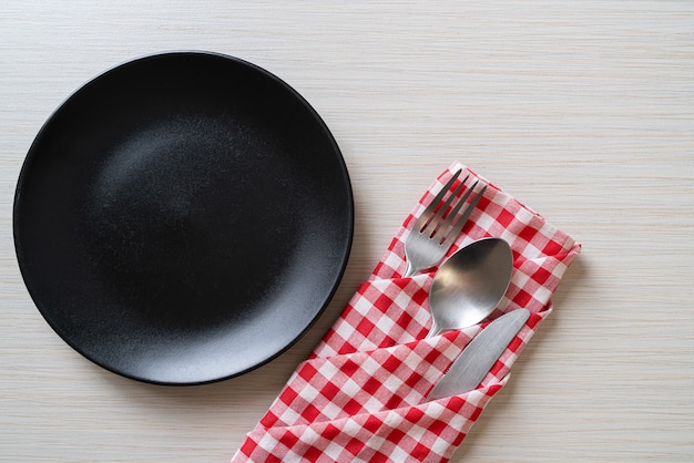 Assiette vide ou plat avec couteau, fourchette et cuillère sur planche de bois