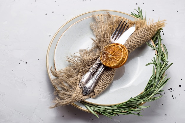 Assiette vide rustique avec une serviette en jute et des couverts