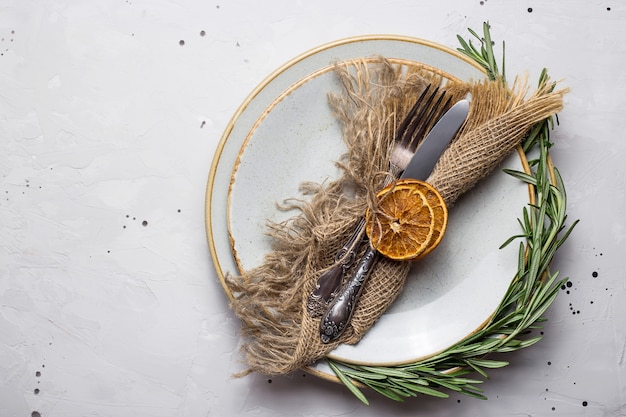 Assiette vide rustique avec une serviette en jute et des couverts