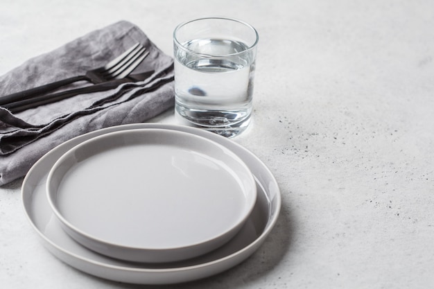 Assiette vide et verre d&#39;eau, fond blanc. Concept de jeûne médical.