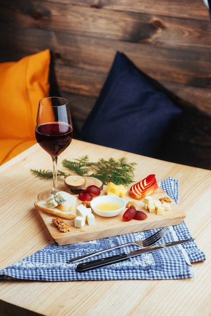 Assiette de vin rouge et de fromages assortis avec des fruits.