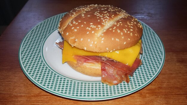 Photo assiette vintage verte et blanche avec un savoureux hamburger fait maison sur une table en bois