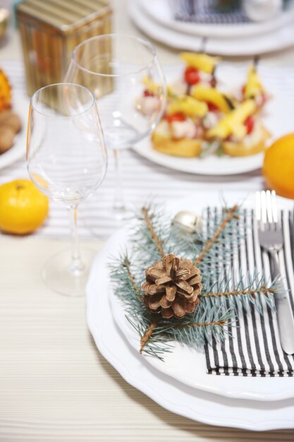 Assiettes blanches avec couverts sur une table de Noël