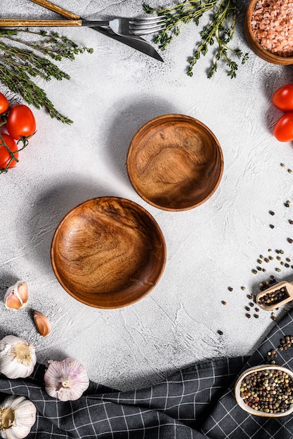 Assiettes en bois vides noires au centre de verts crus frais