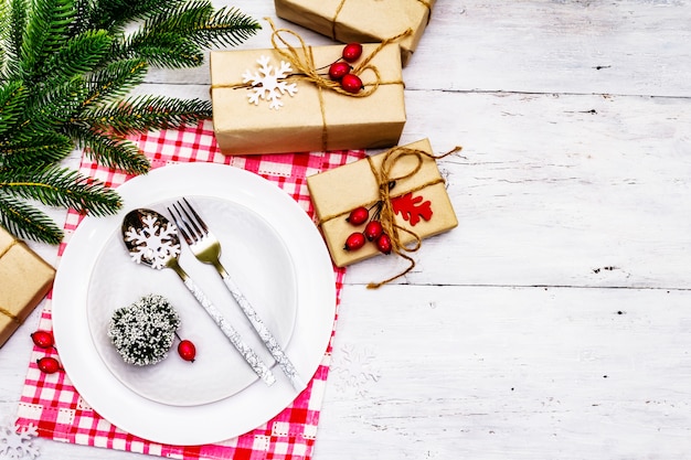 Assiettes en céramique avec cadeau et serviette en lin sur planche de bois