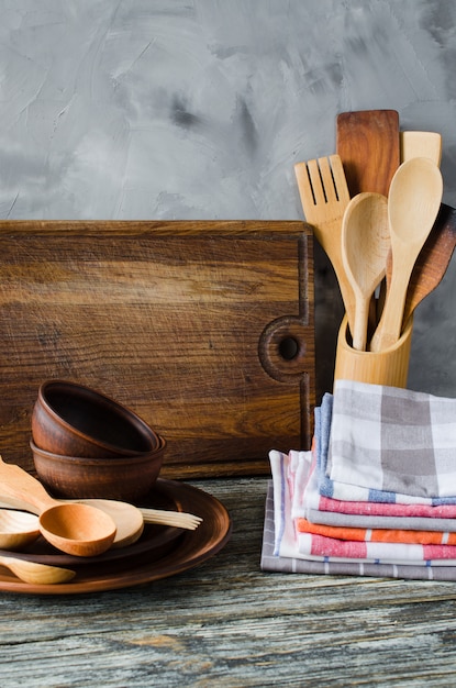 Assiettes en céramique, couverts en bois ou en bambou, planche à découper vintage et serviettes à l&#39;intérieur de la cuisine.