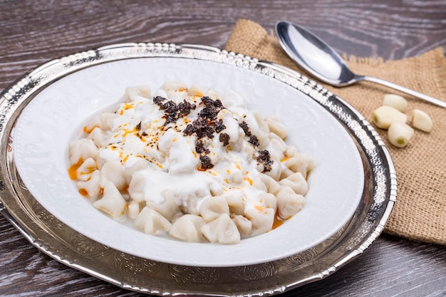 Assiettes de cuisine turque traditionnelle. Manti à la sauce tomate