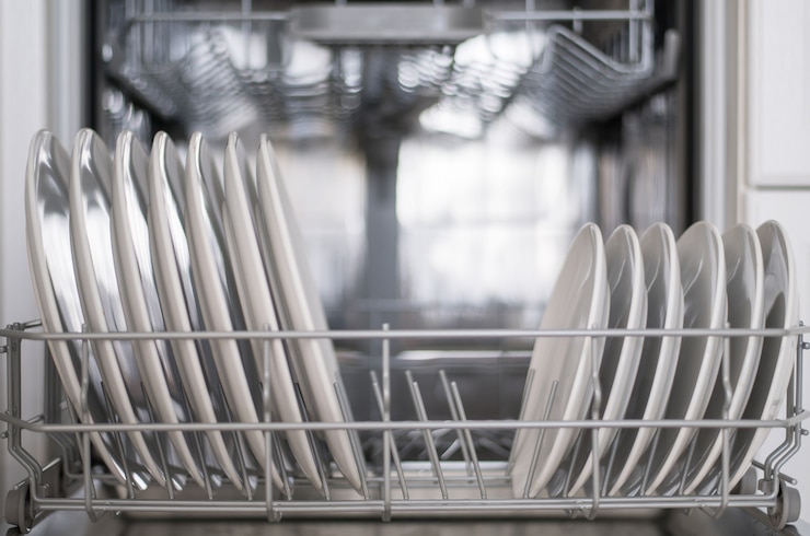 Photo les assiettes plates blanches grandes et petites sont chargées dans le lave-vaisselle