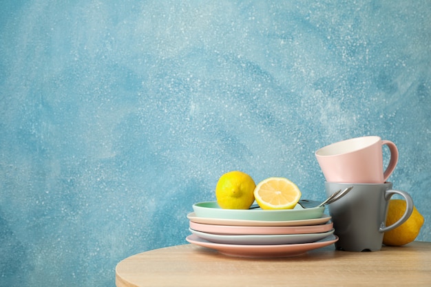 Assiettes et tasses avec des citrons empilés sur une table en bois, espace pour le texte