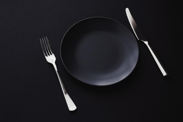 Assiettes vides et argenterie sur fond noir vaisselle haut de gamme pour le dîner de vacances design minimaliste et régime alimentaire