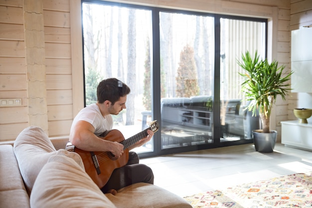 Assis sur un canapé et jouer de la guitare