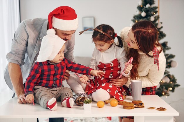 Assis contre le sapin Belle famille célèbre le Nouvel An et Noël à l'intérieur à la maison