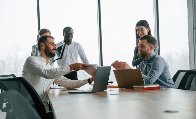 Assis à la table, une équipe de employés de bureau est ensemble à l'intérieur.