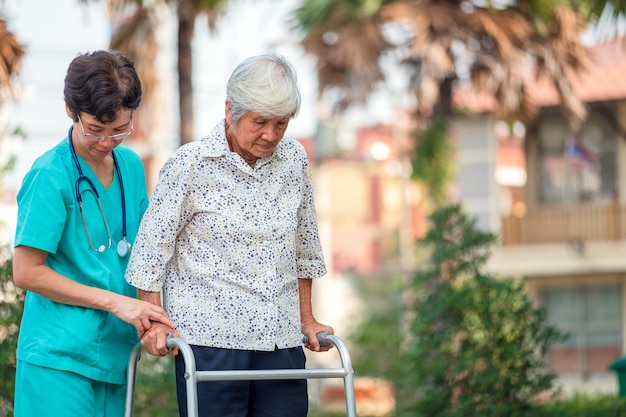 Assistance et soins d'un médecin Patiente asiatique âgée ou âgée dans un hôpital de soins infirmiers, assise dans un fauteuil roulant : idée médicale robuste et saine