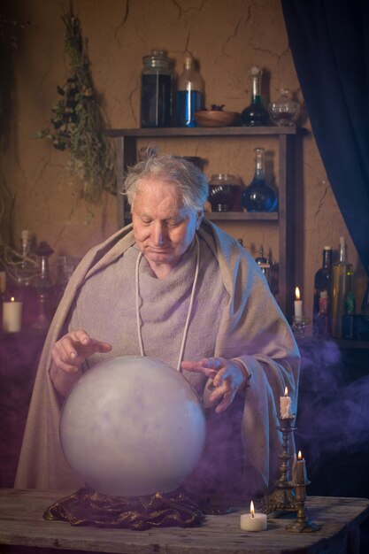 Assistant âgé avec boule de cristal