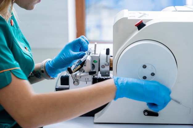 L'assistant de laboratoire travaille sur une section de microtome rotative et fait des lames de microscope