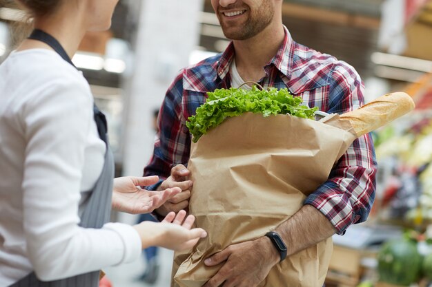 Assistant de magasin parlant au gros plan du client