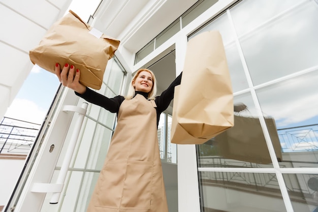 Assistant de magasin tenant un sac d'épicerie