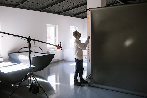 Assistant de mise en place du matériel en studio photo avant la séance photo