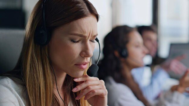 Assistante réfléchie à la recherche d'une solution en gros plan femme inspirée dans le centre de contact