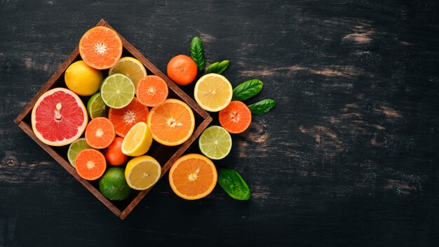 Assortiment d'agrumes dans une boîte en bois Orange mandarine pamplemousse citron Sur un fond en bois Vue de dessus Espace de copie