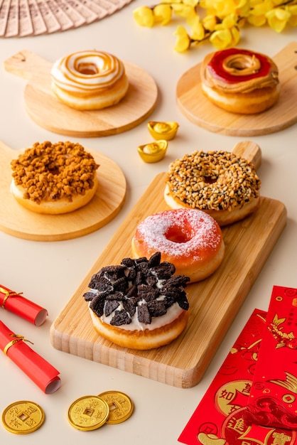 Assortiment de beignets ou assiette de beignets sur plateau en bois et tournage sur fond crème et ornement chinois