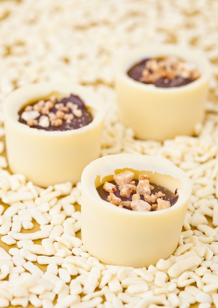 Assortiment de bonbons de luxe au chocolat blanc sur fond doré avec des morceaux de chocolat blanc