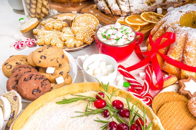 Assortiment de bonbons de Noël faits maison. Ensemble de divers gâteaux au fromage de pâtisserie traditionnelle de Noël, gâteau aux fruits, stollen, pain d'épice, biscuits, panettone. Menu boulangerie, invitation banquet de Noël