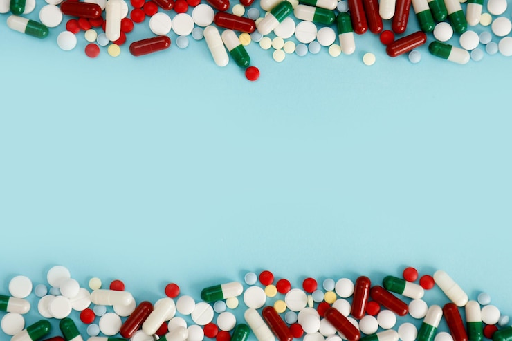 Photo assortiment de capsules de pilules de médicaments pharmaceutiques sur fond bleu de haut en bas avec espace de copie