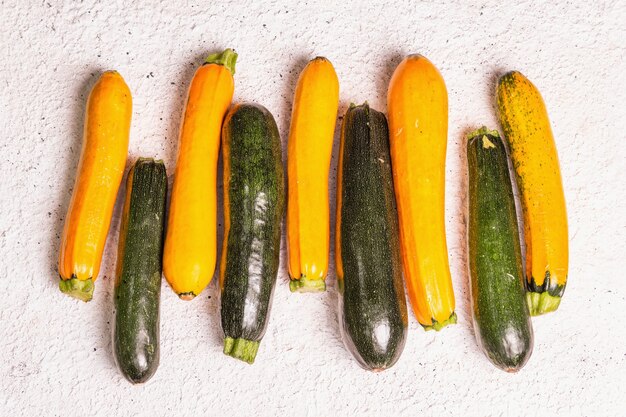 Assortiment de courgettes fraîches. Récolte de légumes mûrs sur fond de plâtre clair, vue de dessus