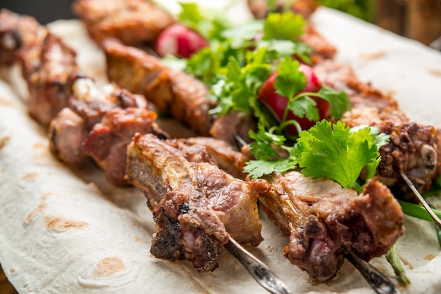 Assortiment de délicieuses viandes grillées aux légumes sur une table de pique-nique plaque blanche pour barbecue en famille