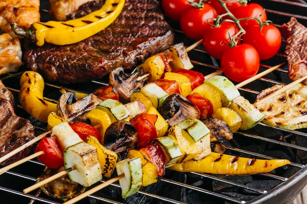 Assortiment de délicieuses viandes grillées avec des légumes sur le barbecue