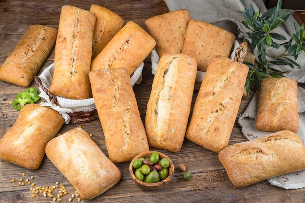 Assortiment de différents types de pain Ciabatta sur un fond de bois rustique