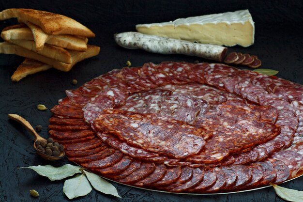 Assortiment de différents types de saucisses au fromage sur un fond sombre.