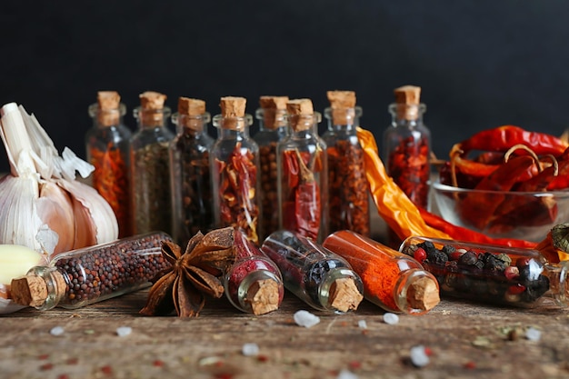 Photo assortiment d'épices sèches dans des bouteilles en verre se bouchent