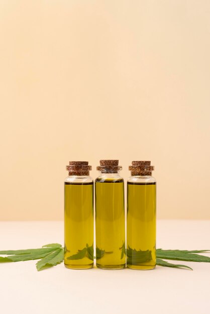 Photo assortiment de feuilles de cannabis et de bouteilles d'huile