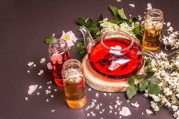 Assortiment de fleurs de thé. Sureau frais, églantier et acacia. Concept d'alimentation saine. Fond de béton de pierre noire, place pour le texte