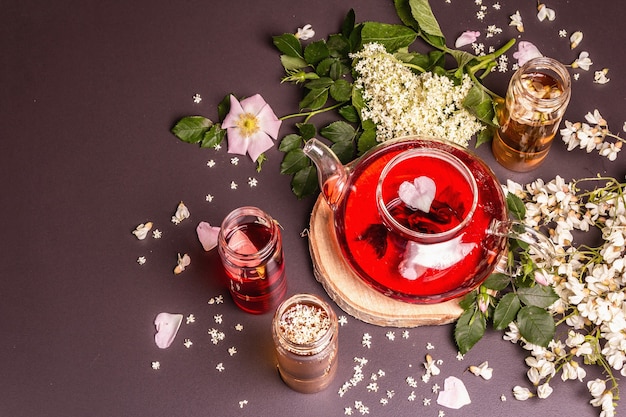 Assortiment de fleurs de thé. Sureau frais, églantier et acacia. Concept d'alimentation saine. Fond de béton de pierre noire, vue de dessus