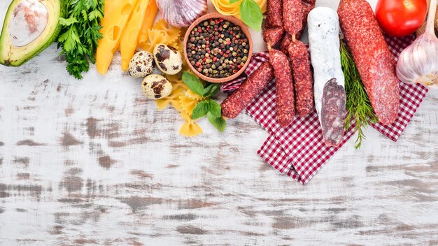 Assortiment de fromage à la saucisse et de légumes frais Sur un fond en bois blanc Vue de dessus Espace de copie