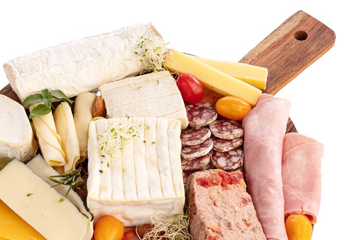 Photo assortiment de fromages et charcuteries sur un plateau en bois sur une table