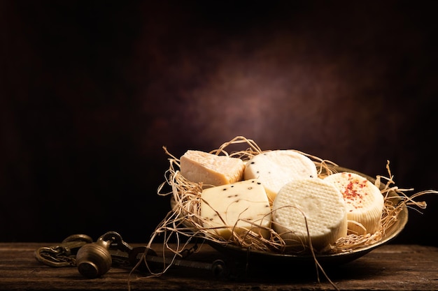 Assortiment de fromages faits maison sur une table en bois avec un fond en bois se bouchent