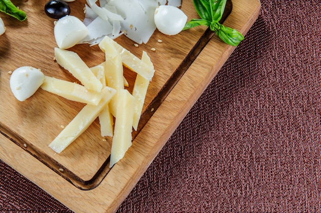 Assortiment de fromages sur un fond en bois de planche à découper rustique.