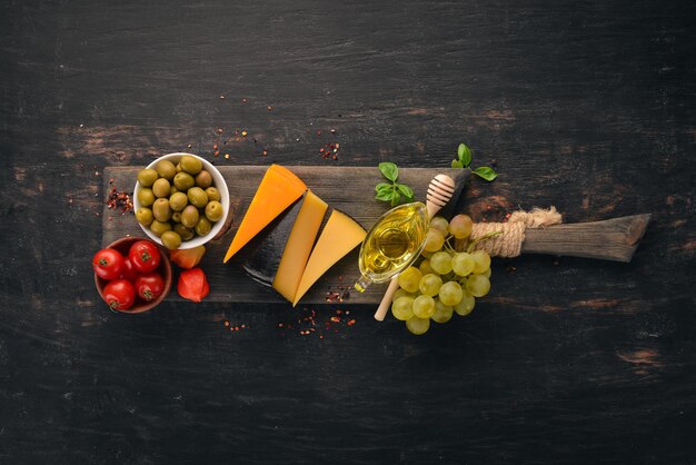 Assortiment de fromages à pâte dure Vue de dessus Sur un fond en bois noir Espace de copie gratuit