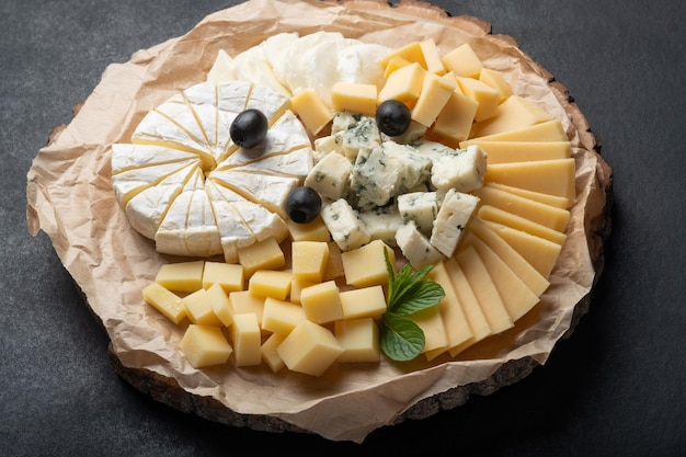 Assortiment de fromages sur plaque sur fond sombre